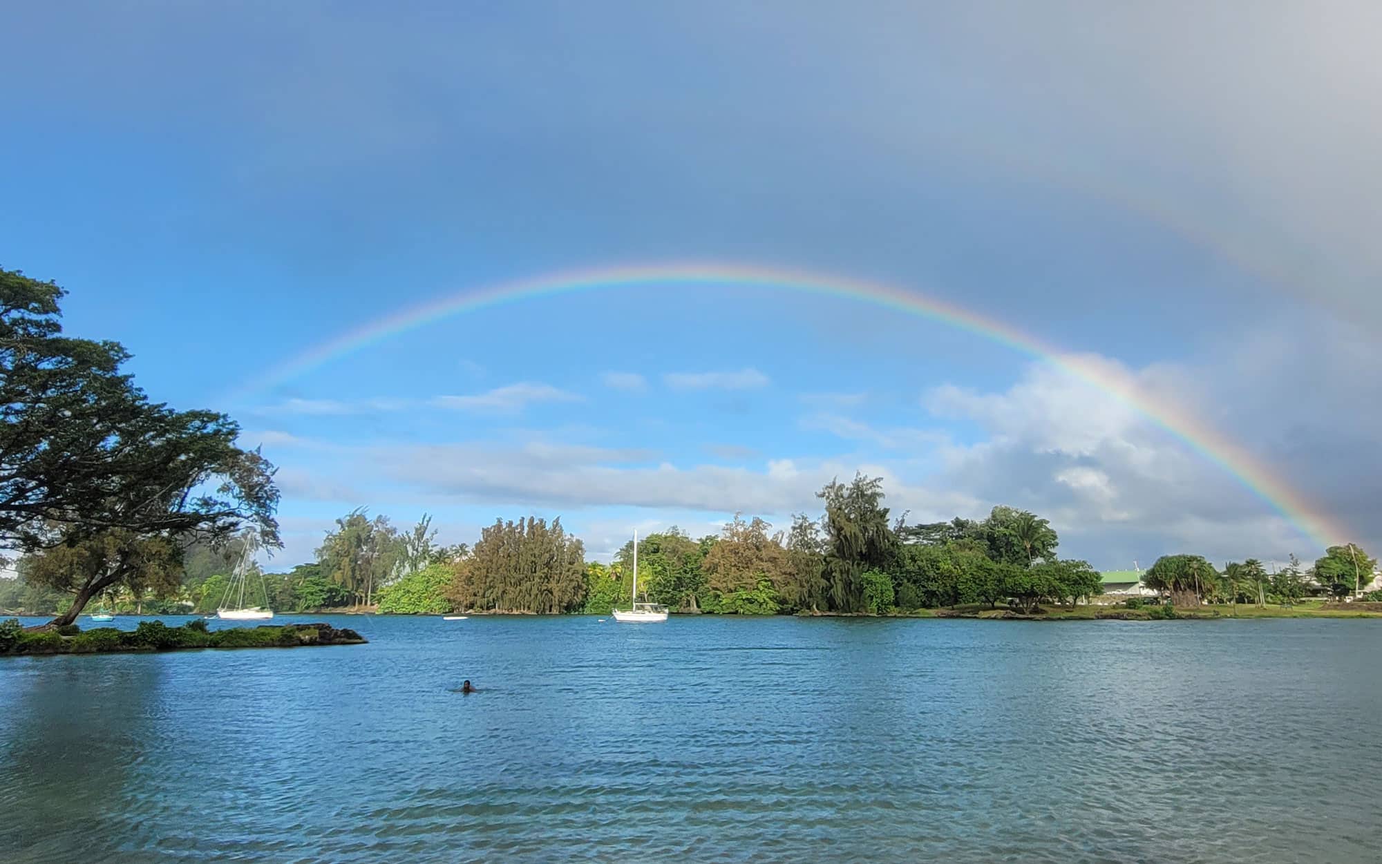 Rainbow over sailboat in Hilo Bay.